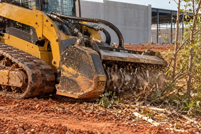 Forestry mulcher working on brush at a commercial property edge