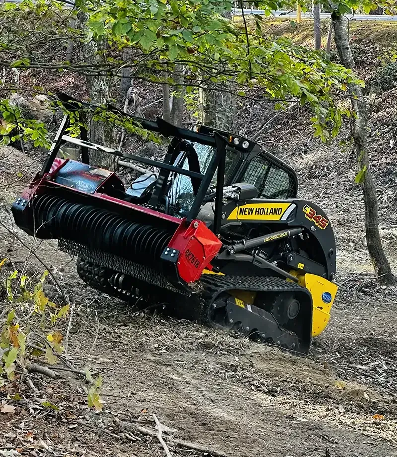 Compact forestry mulcher working on a wooded slope