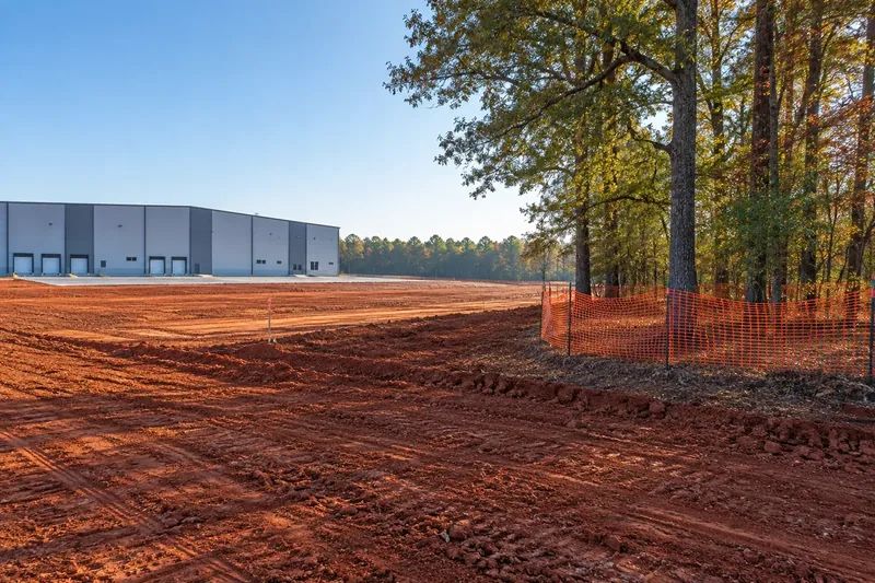 Prepared commercial ground with retained vegetation and site infrastructure