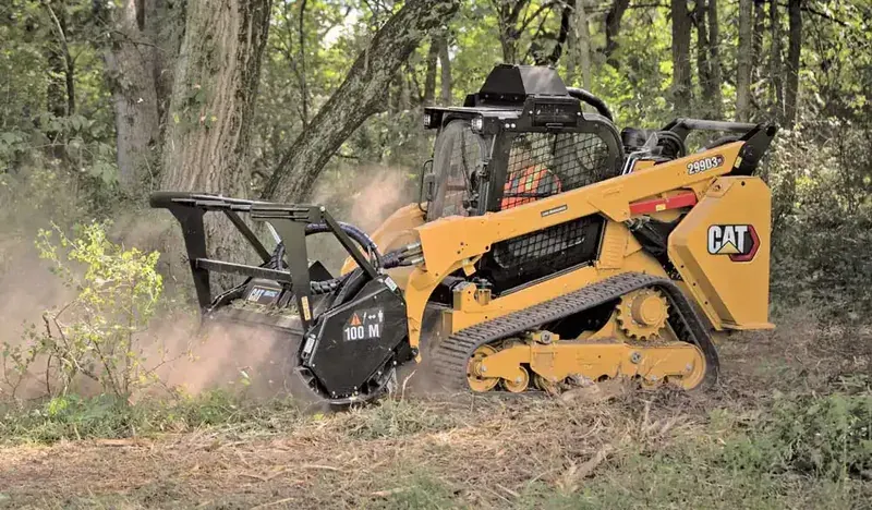 Tracked equipment clearing brush on wooded land