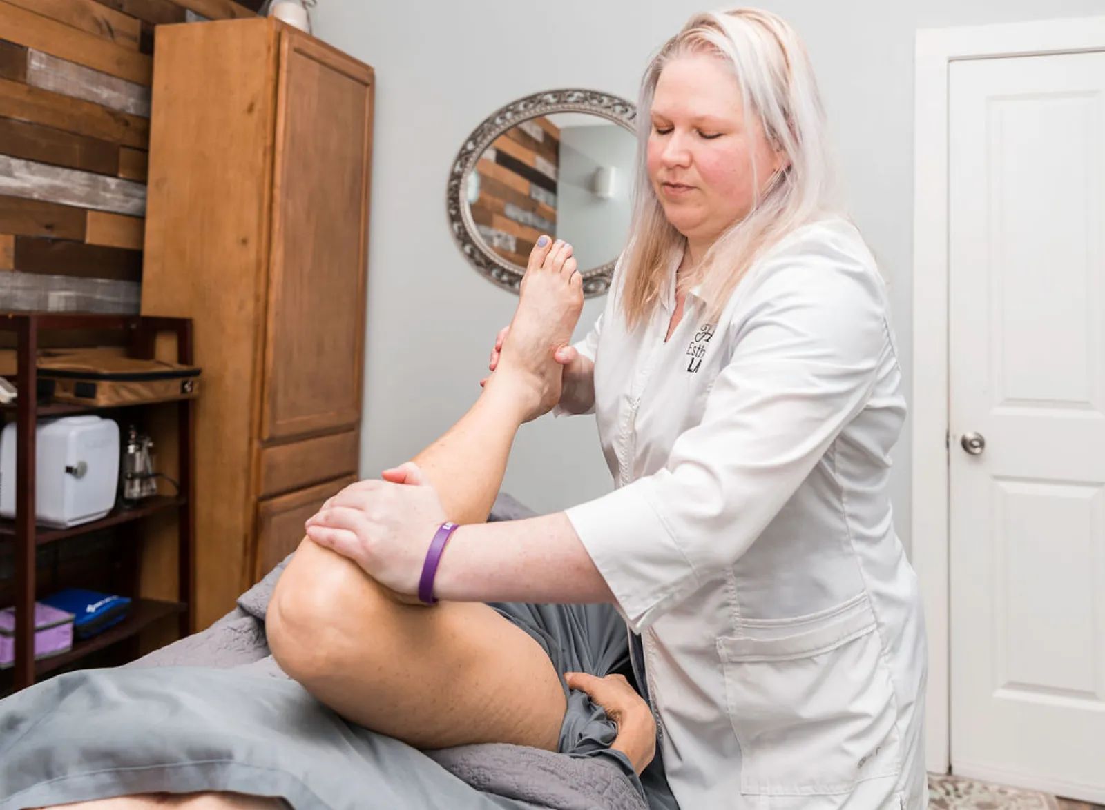 Hart Fandridge checking a client's leg during a posture assessment in Hoschton, GA