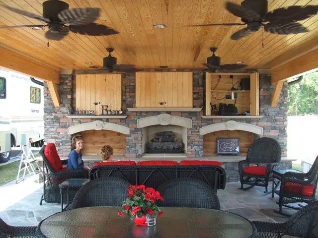 Covered pavilion with outdoor kitchen and stone fireplace