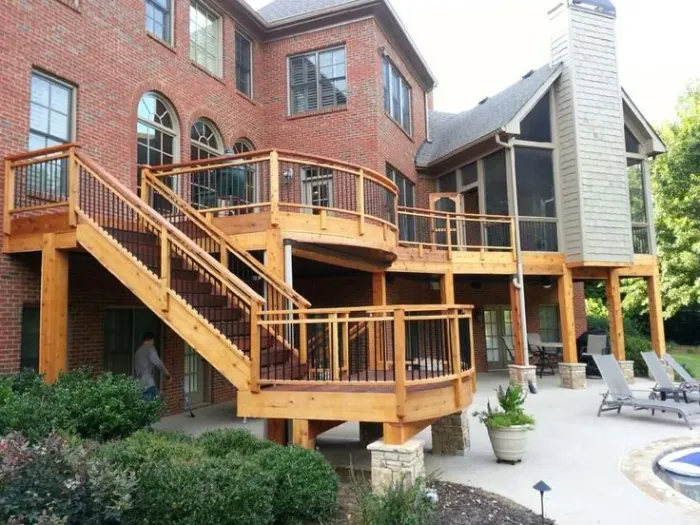 Wood deck with dark railings above a stone patio