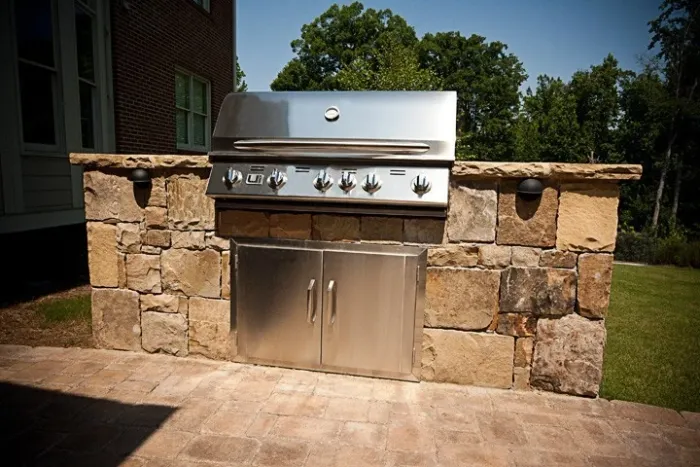 Stone grill island with a stainless steel built-in grill