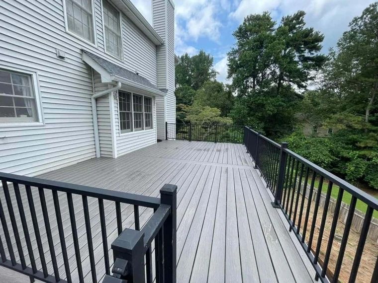Broad composite deck and steps with black metal railings