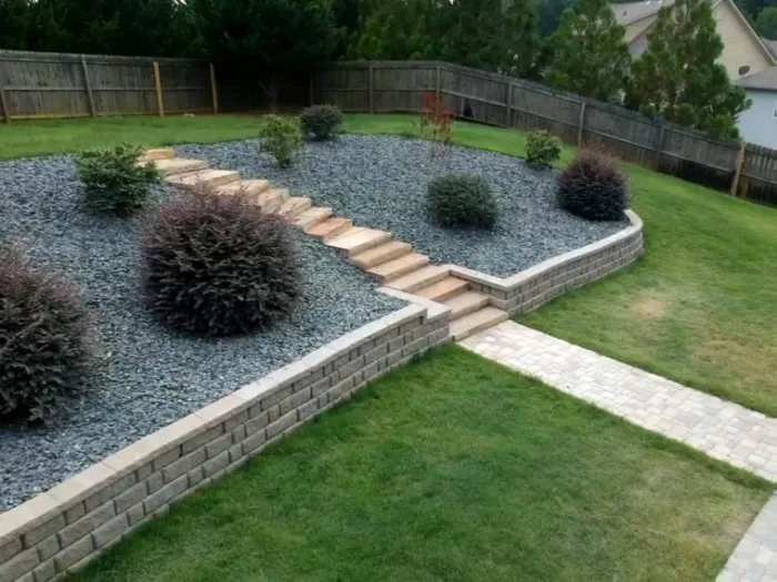 Tiered retaining walls and central stairs framing planted garden beds