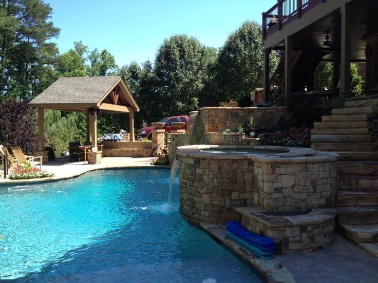 Swimming pool and stone terrace beside a poolside pavilion