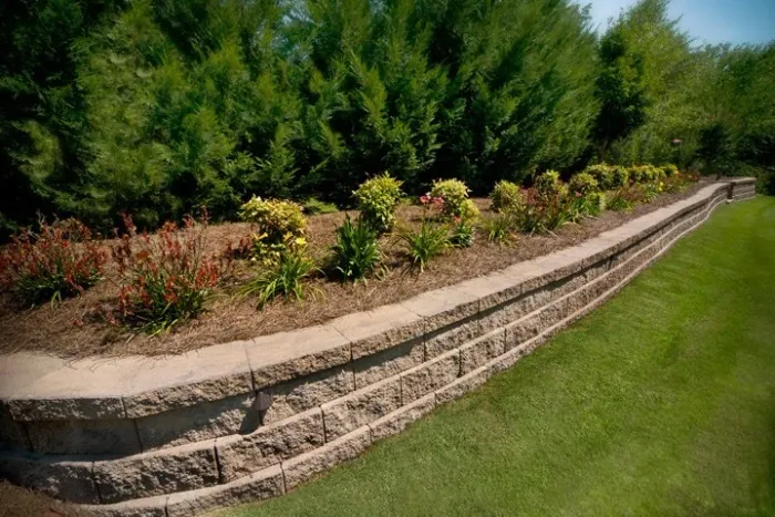 Curving block retaining wall supporting a planted garden border