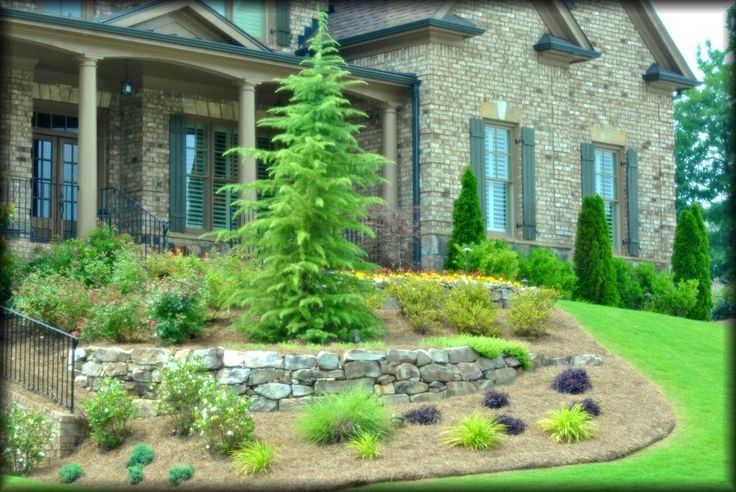 Stone garden wall and mixed planting beds around a landscaped home