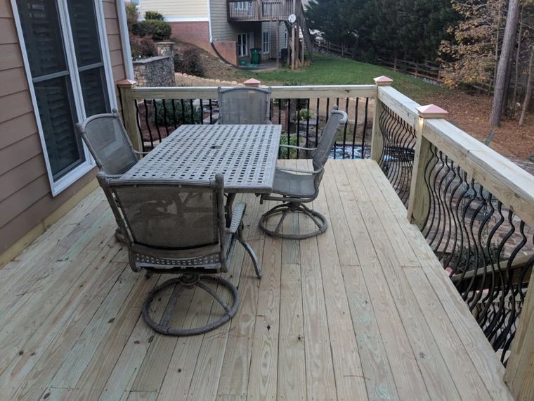 Wood deck with outdoor dining furniture and dark metal balusters