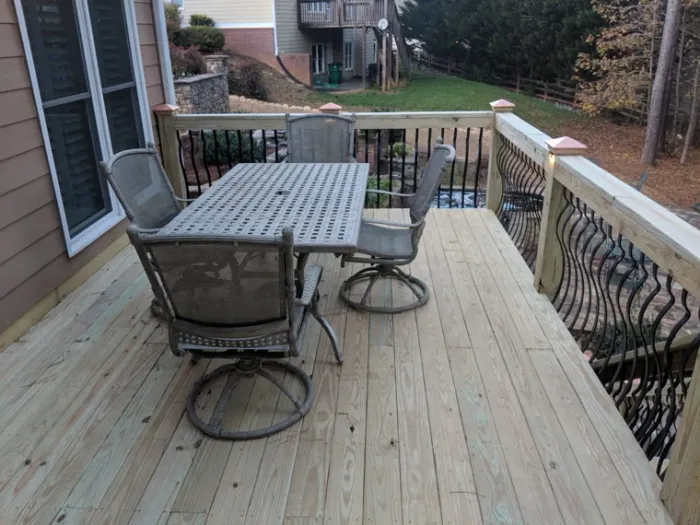 Wood deck with outdoor dining furniture and dark metal balusters