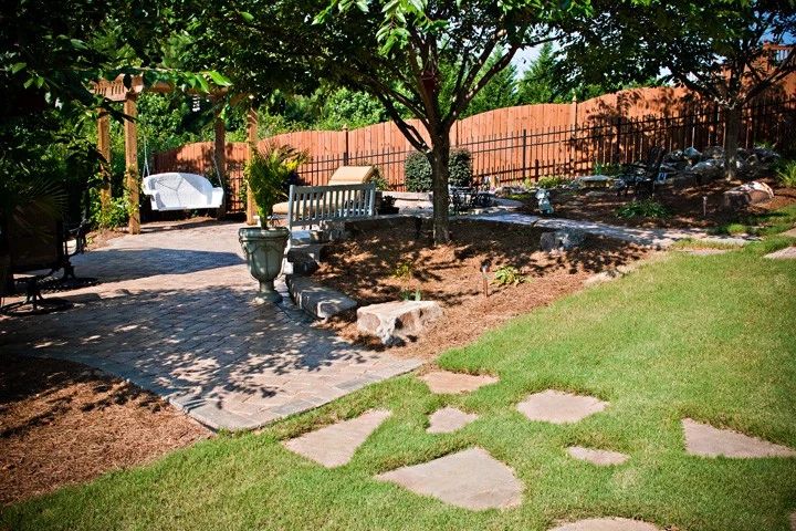 Flagstone path leading from a lawn into a furnished garden patio