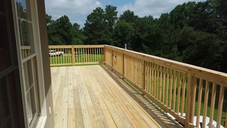 Wide wood deck with a view across mature trees