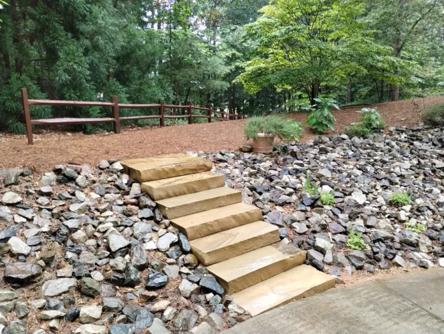 Stone steps crossing a landscaped slope with a dry creek bed