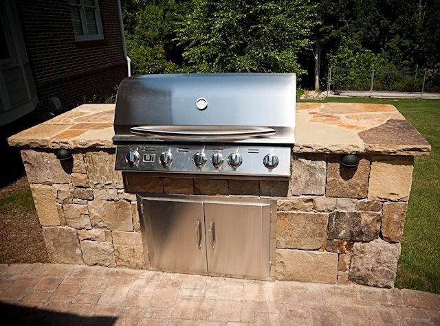 Stainless steel grill set in a natural stone outdoor island