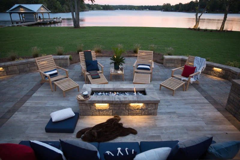 Furnished lakeside patio and fire pit at sunset