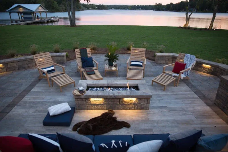 Furnished lakeside patio and fire pit at sunset