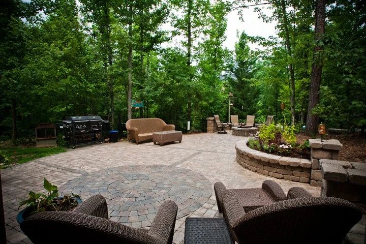 Broad paver patio with lounge furniture, outdoor dining, and planted stone walls