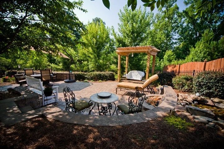 Woodland garden patio with a pergola, outdoor dining, and lounge seating