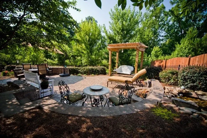 Woodland garden patio with a pergola, outdoor dining, and lounge seating