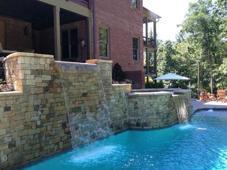 Swimming pool with a tiered stone waterfall