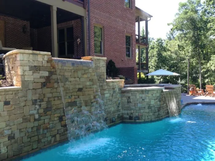 Swimming pool with a tiered stone waterfall