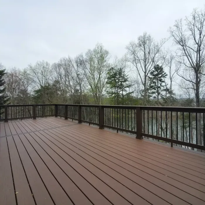 Wide composite deck with dark rails and views of surrounding trees