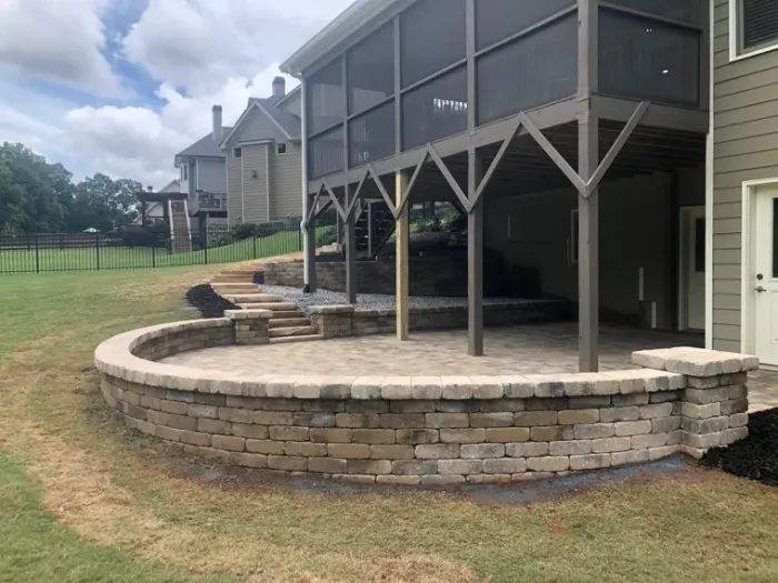 Curved block retaining wall creating level space beneath a raised porch