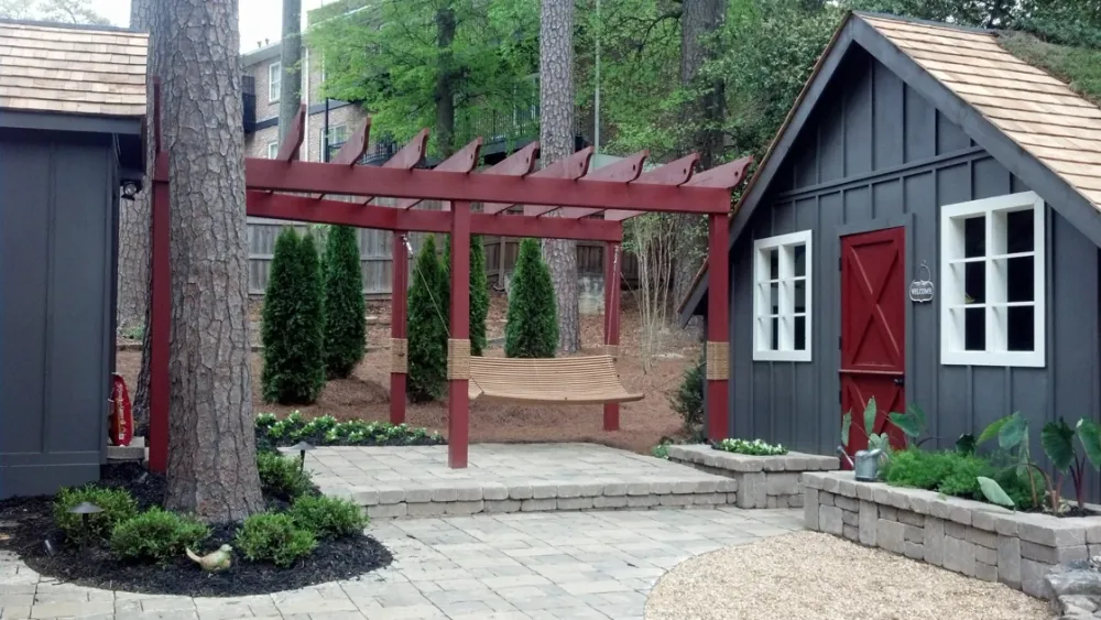 Red timber pergola over stone steps and a landscaped patio