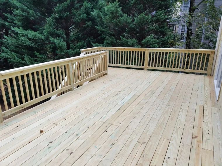 Spacious wood deck overlooking a wooded backyard