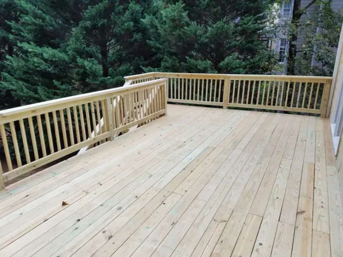 Spacious wood deck overlooking a wooded backyard