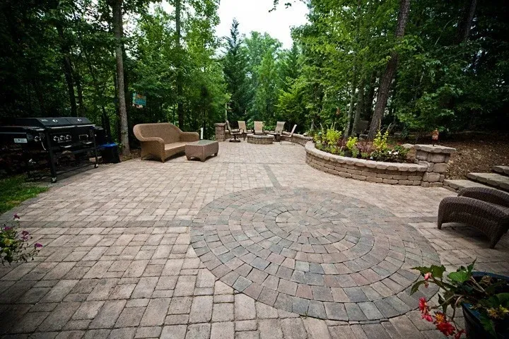 Paver patio with outdoor seating, dining furniture, and curved planting beds