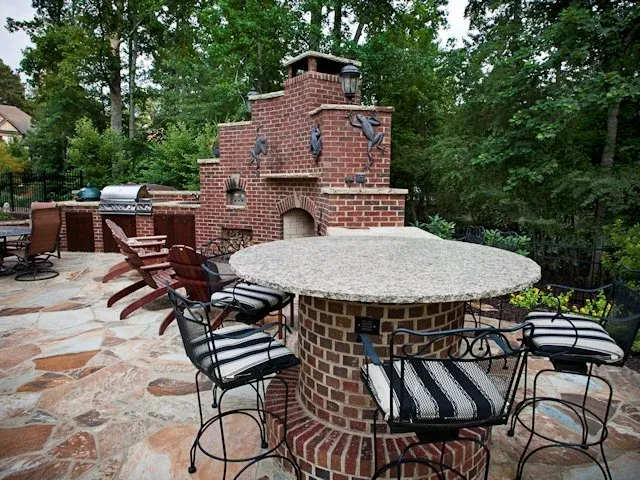 Brick pizza oven and outdoor kitchen with stone paving and bar seating