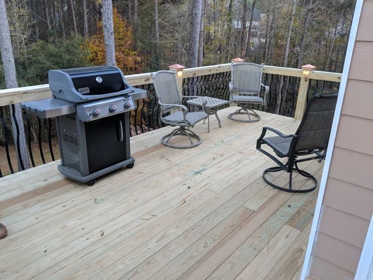 Wood deck furnished for outdoor cooking and seating