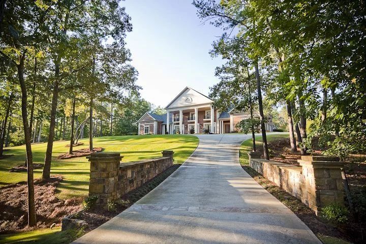 Paved driveway with stone entrance walls and established landscaping