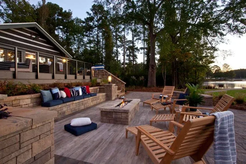 Lakeside patio with stone walls, fire feature, and comfortable outdoor seating