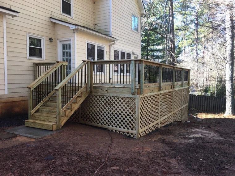 Wood deck with wide stairs, dark railings, and lattice screening