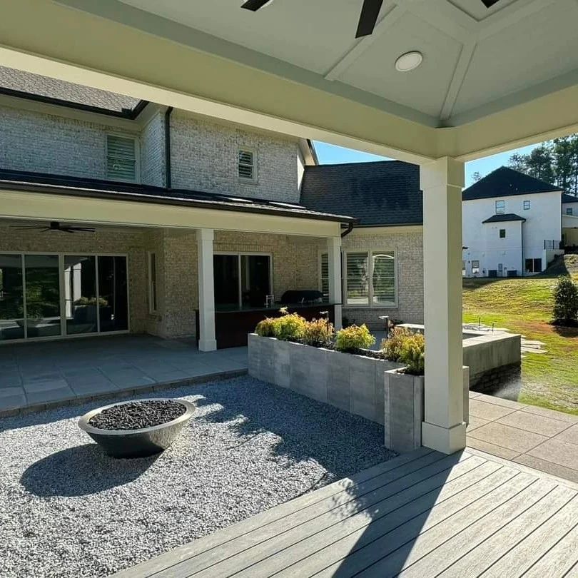 Sheltered backyard seating and a fire bowl beside a raised planter