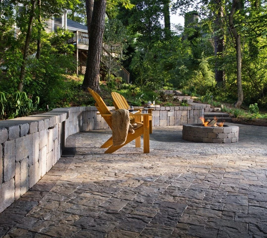 Yellow Adirondack seating beside a stone fire pit and curved patio wall