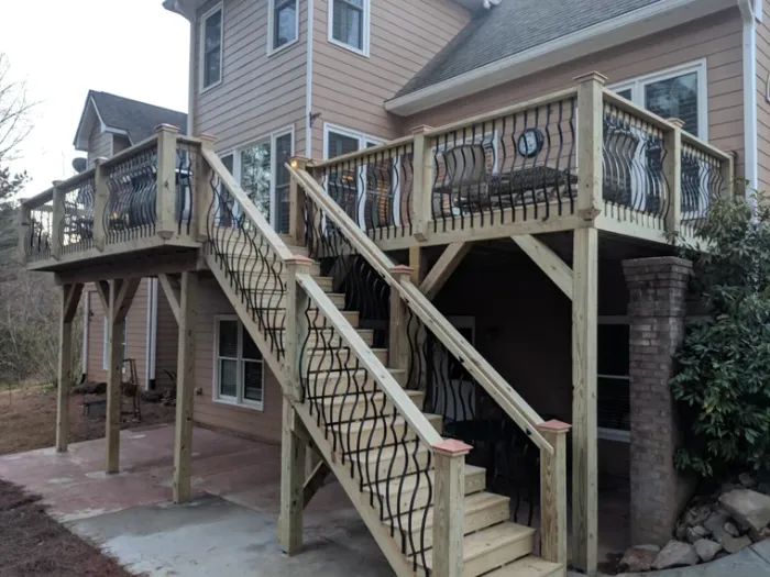 Wood deck with wide stairs and decorative dark metal balusters