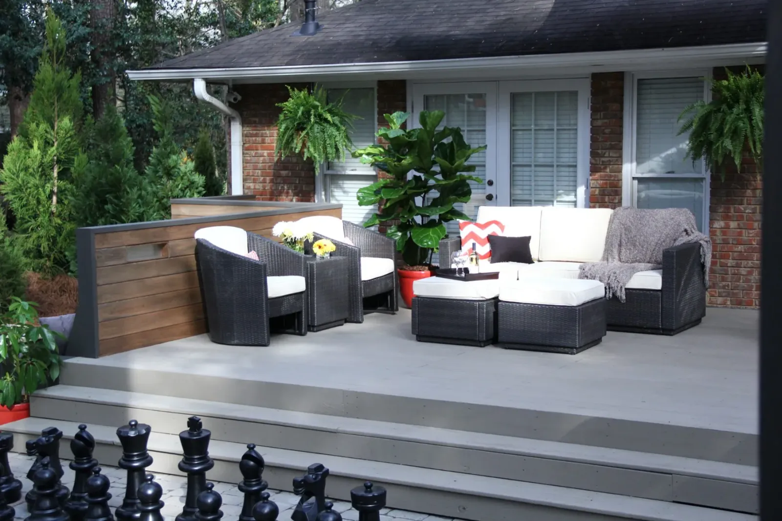 Finished composite deck with broad steps, lounge seating, and lush planting