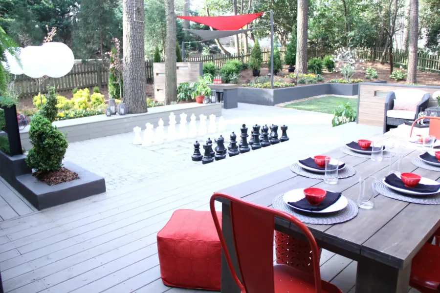 Composite deck arranged for outdoor dining in a landscaped backyard