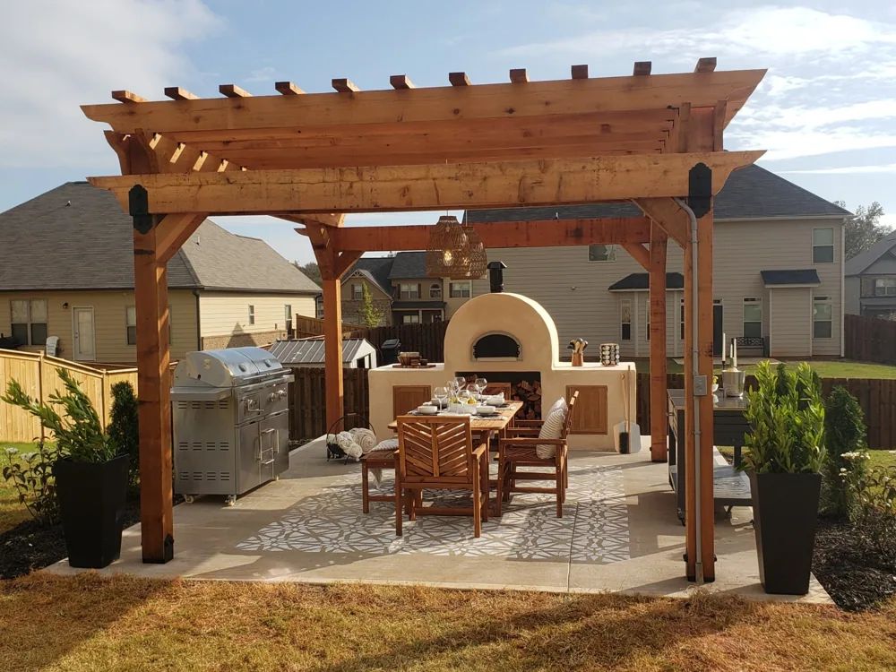 Outdoor kitchen and dining area beneath a timber pergola