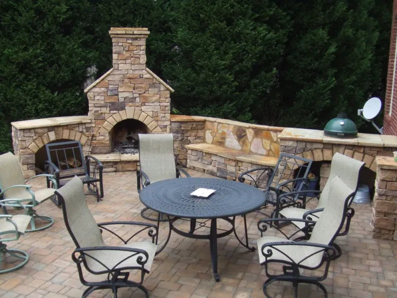 Outdoor stone fireplace beside patio dining furniture