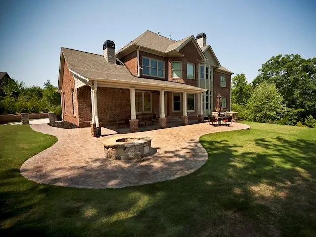 Covered porch and curved patio opening onto a finished lawn