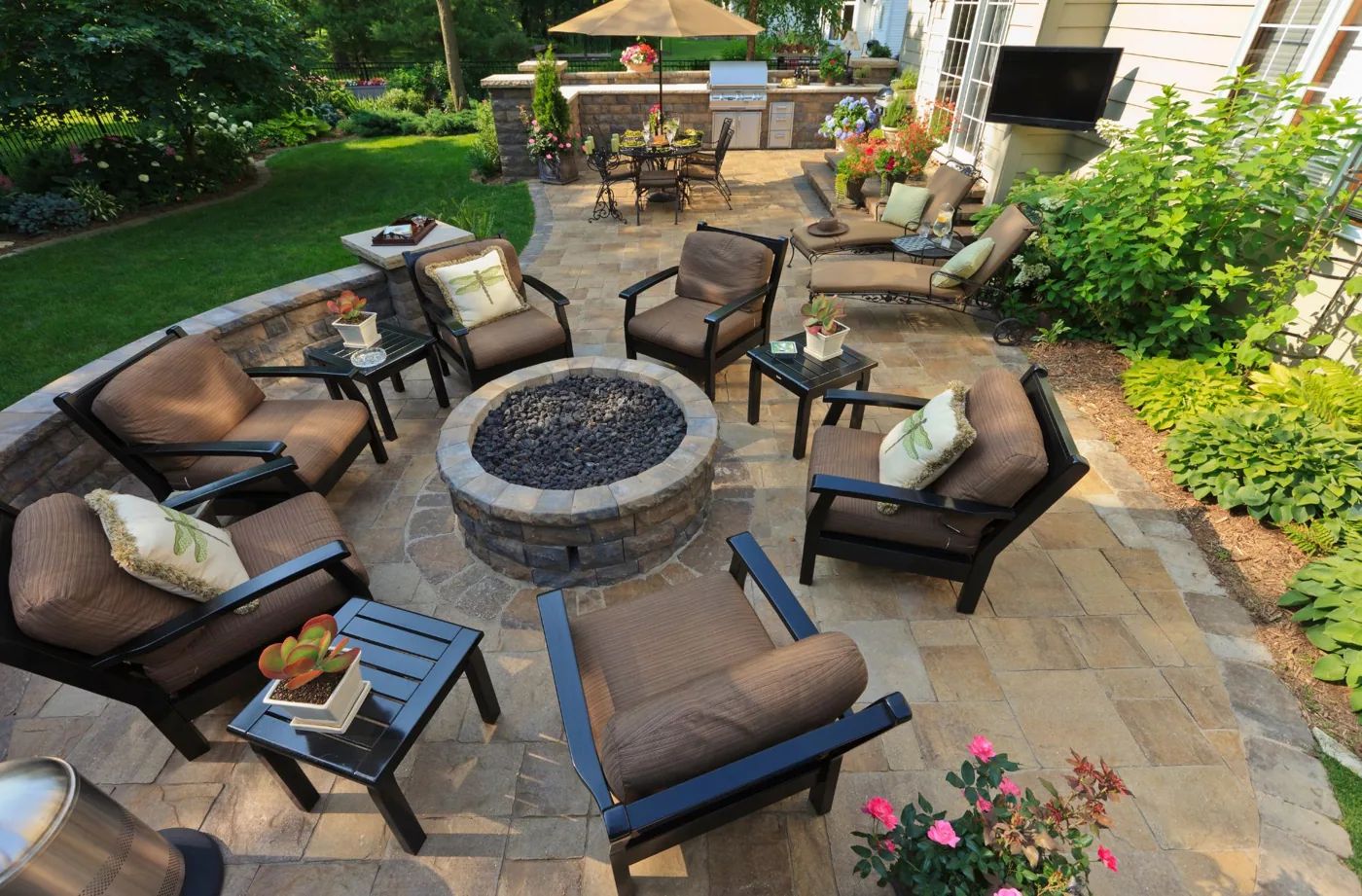 Furnished outdoor living space with a fire pit, paver patio, and garden seating
