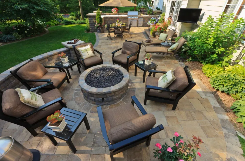 Furnished outdoor living space with a fire pit, paver patio, and garden seating