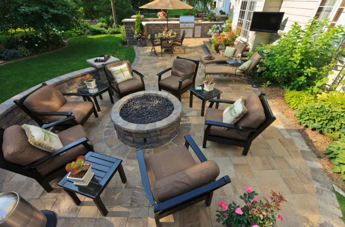 Furnished outdoor living space with a fire pit, paver patio, and garden seating