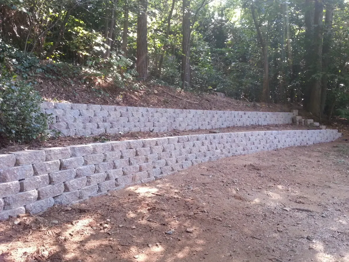 Two-tier retaining wall built into a wooded slope