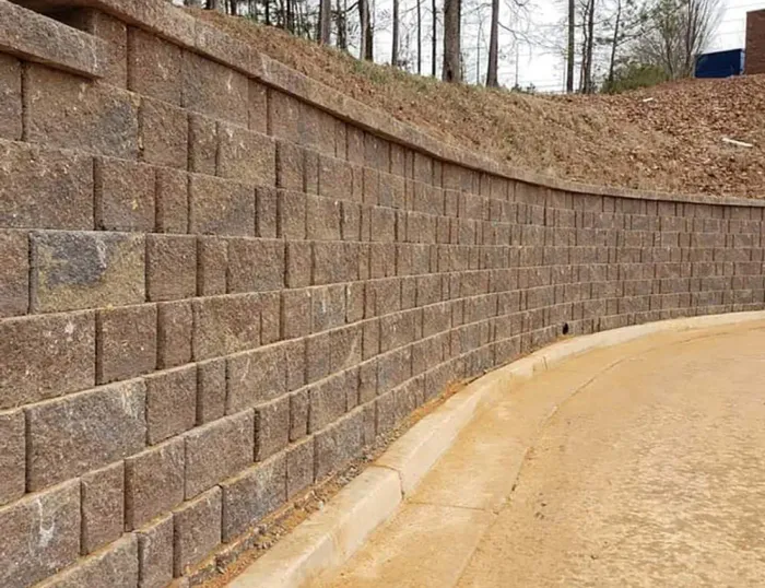 Curved segmental block retaining wall beside a paved area